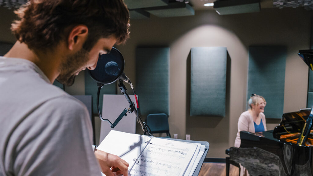 Gabriel Coll-Bettencourt looking at notebook while standing at microphone.