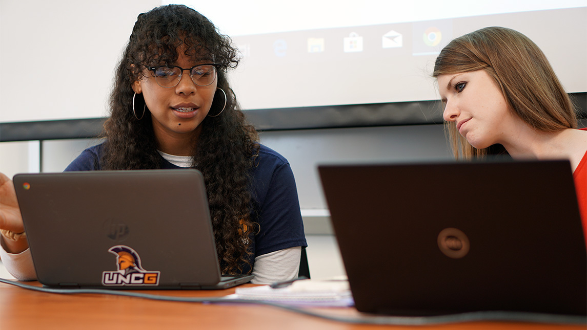 Students look at their laptops.