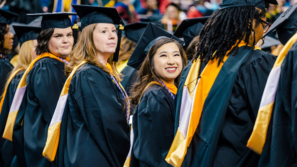 Graduate students smile at their Commencement.