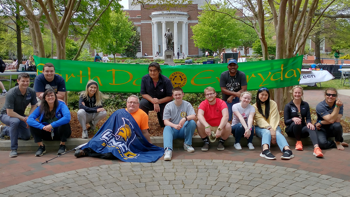 Students gather around an Earth Day banner.