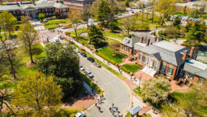 Aerial view of campus shows cars arriving and students walking.