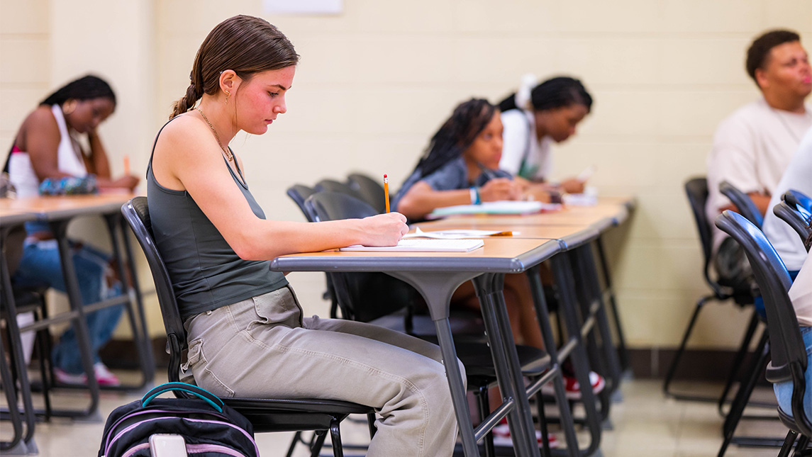 Students take notes in a classroom.