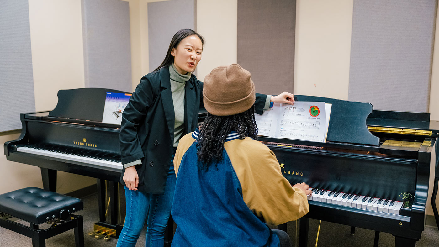 A young person receiving piano instruction with her teacher as part of UNCG's Community Music Lessons Program.