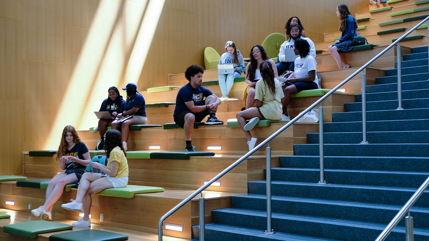 Groups of students studying in the Nursing Building’s atrium by the stairway.