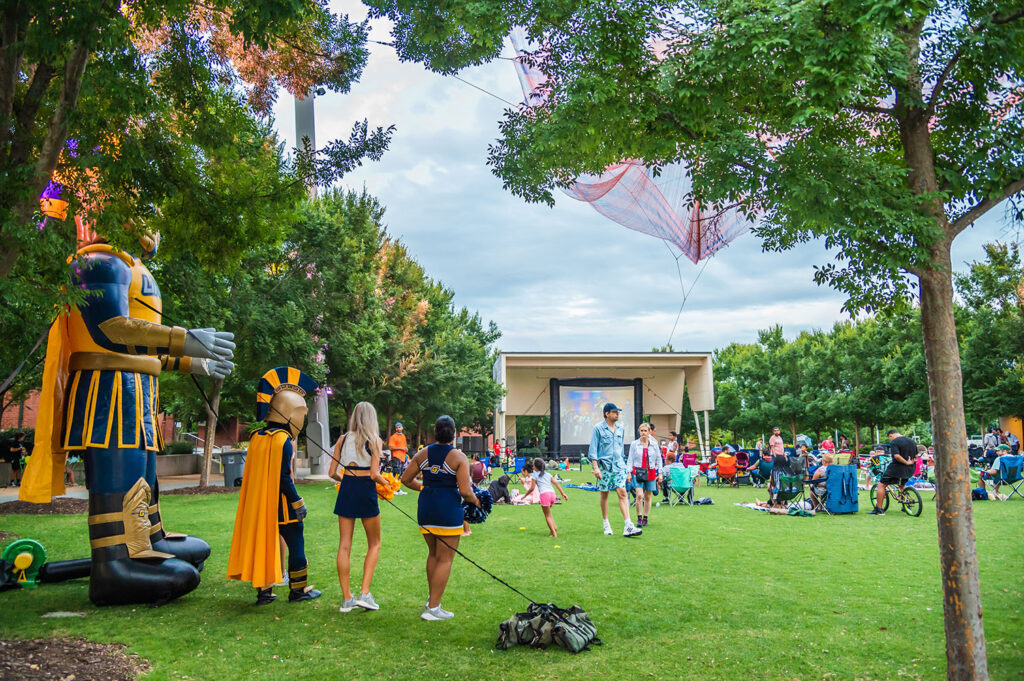 footage of Spartan Cinema at LeBauer park, Spiro blow up, Spiro, cheerleaders, audience.