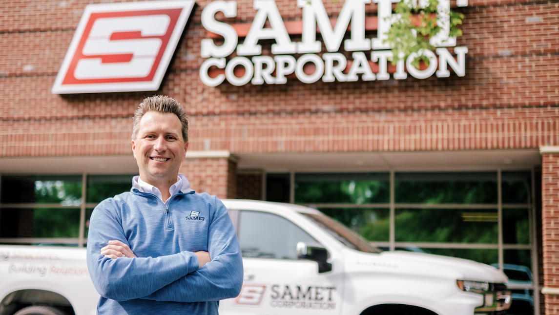 Brian Hall stands outside in front of the Samet Corporation building.