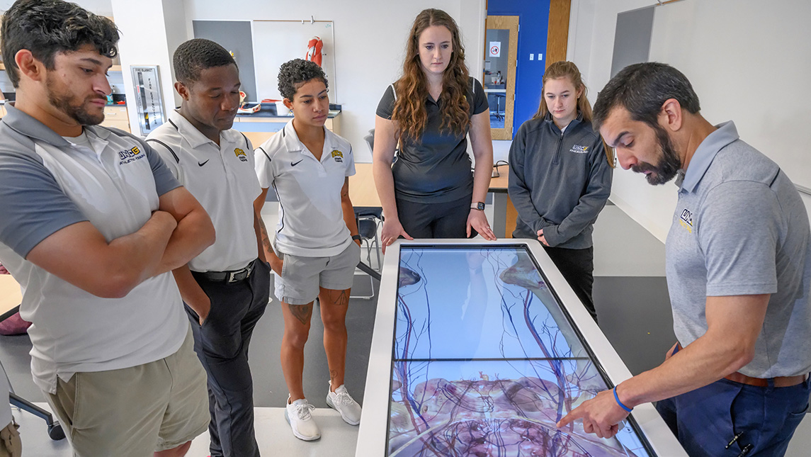 Dr. Aaron Terranova shows UNCG kinesiology students an Anatomage Table that creates 3D visual of inside the human body.