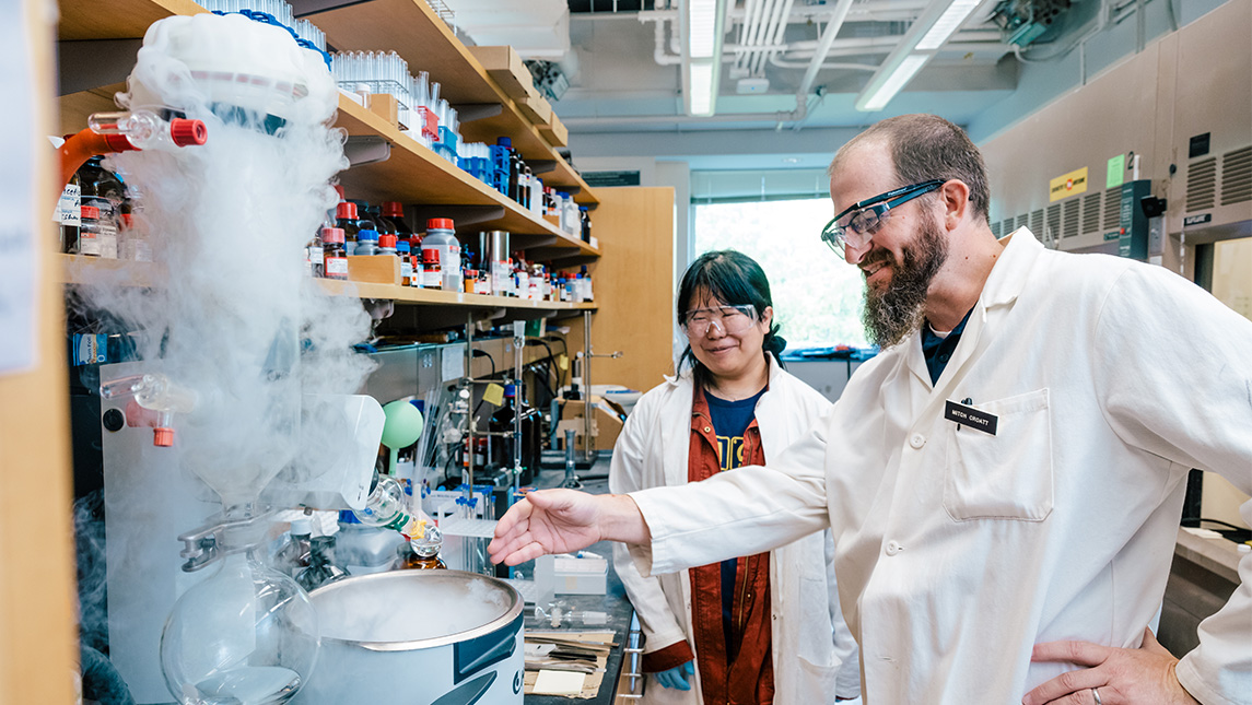 Student and faculty member work in the lab with dry ice.