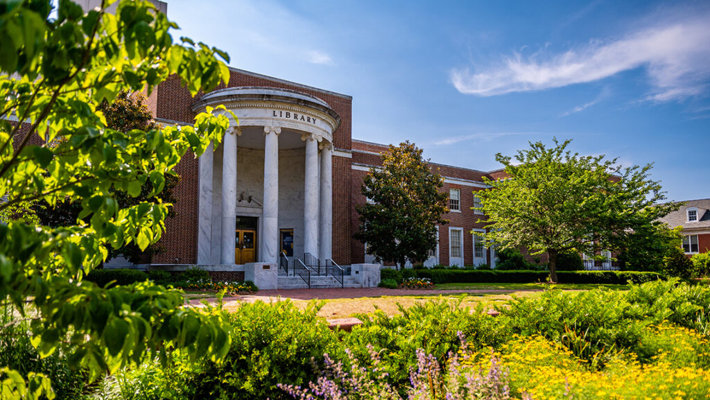A beauty shot of UNCG's Jackson Library with blue skies and green landscaping framing the shot.