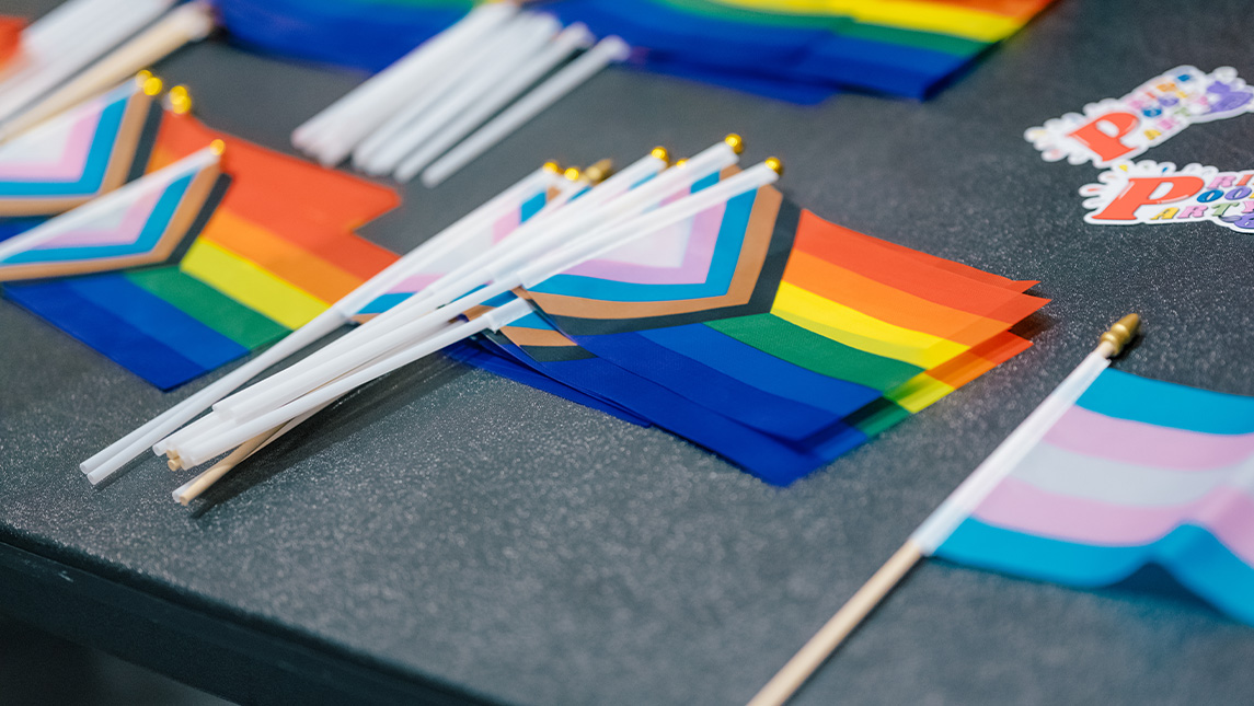 Pride flags are displayed on a table