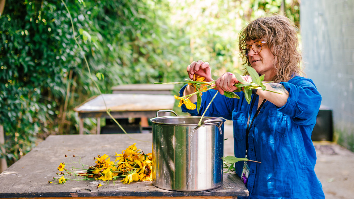 UNCG lecturer Tara Webb works with flowers to make dyes
