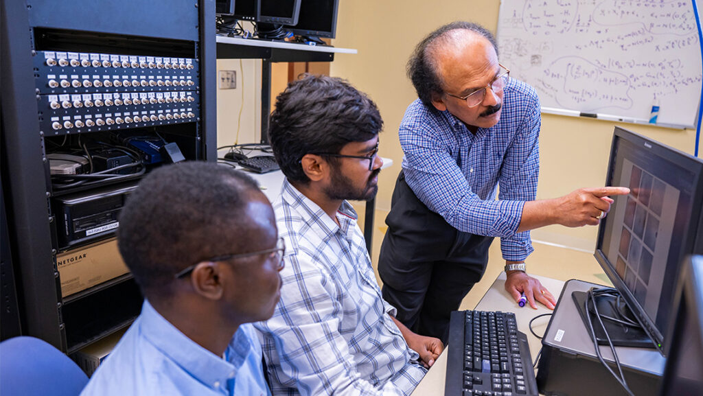 UNCG computer science professor Dr. Shan Suthaharan works with students.