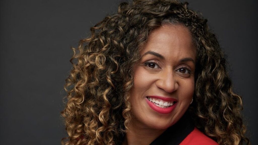 Professional portrait of Tia Wiggins wearing a red and black suit.
