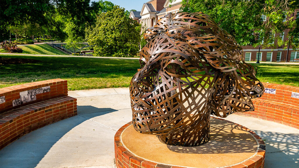 The bronze Woman's College Tribute sculpture on the UNCG campus.