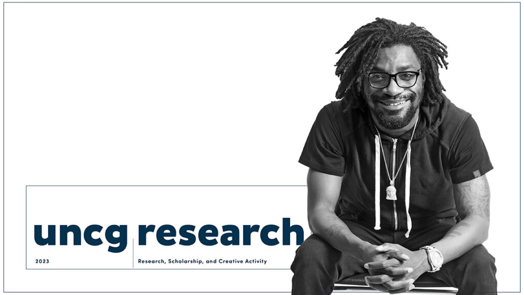 A black and white photograph of a man sitting and smiling next to the words "UNCG Research 2023: Research, Scholarship and Creative Activity."