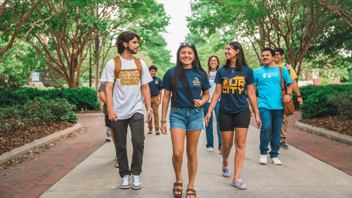 Four UNCG students walk down College Ave