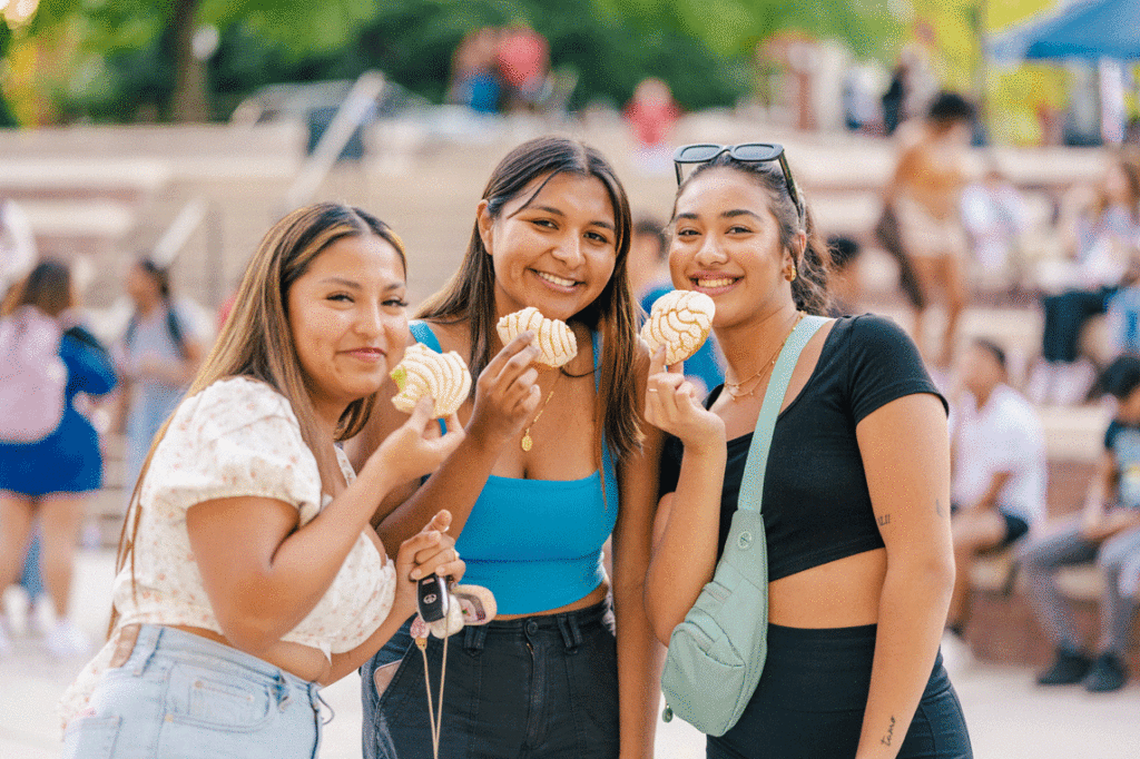 Three UNCG students eating conchas