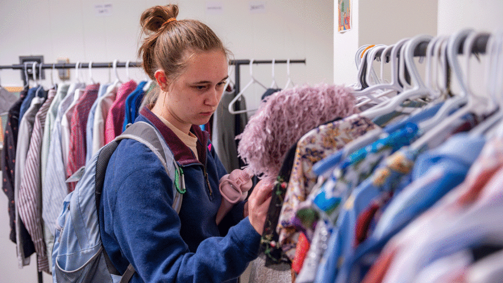 UNCG student looks over clothing in the Women's, gender, and sexuality studies open closet