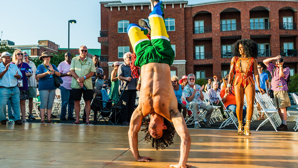 A man breakdances for a crowd.