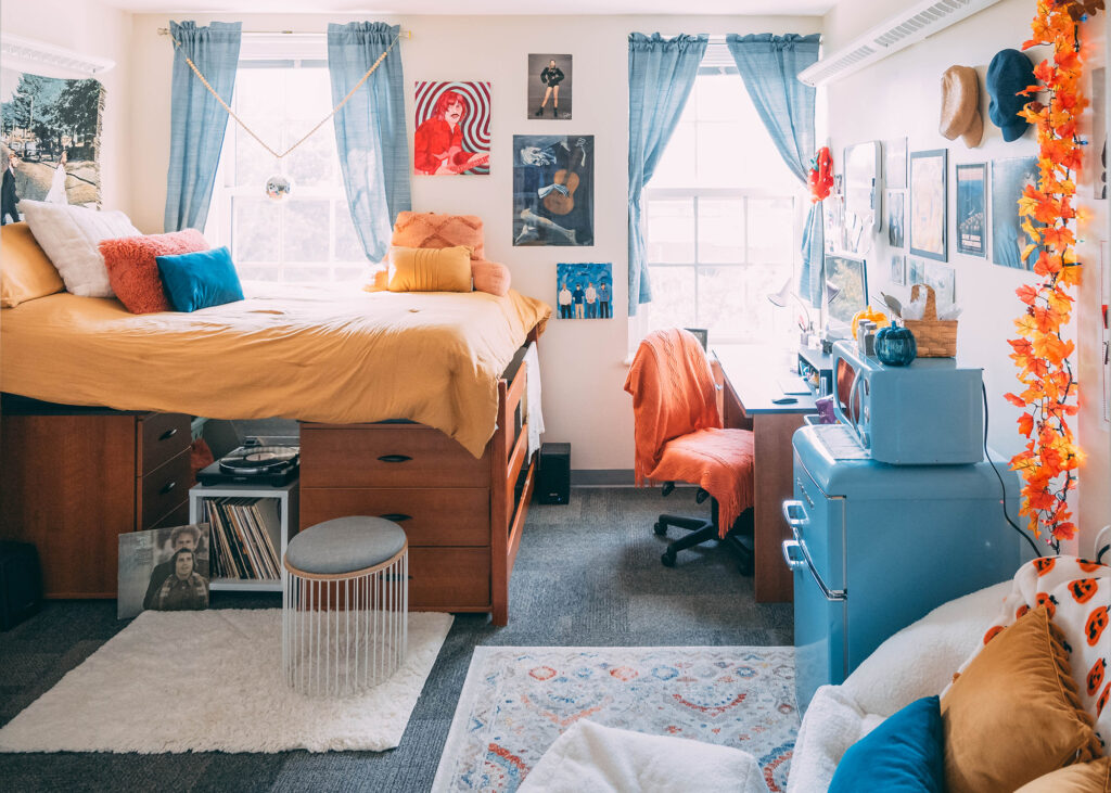 Dorm room decorated with in teal, mustard and orange tones.