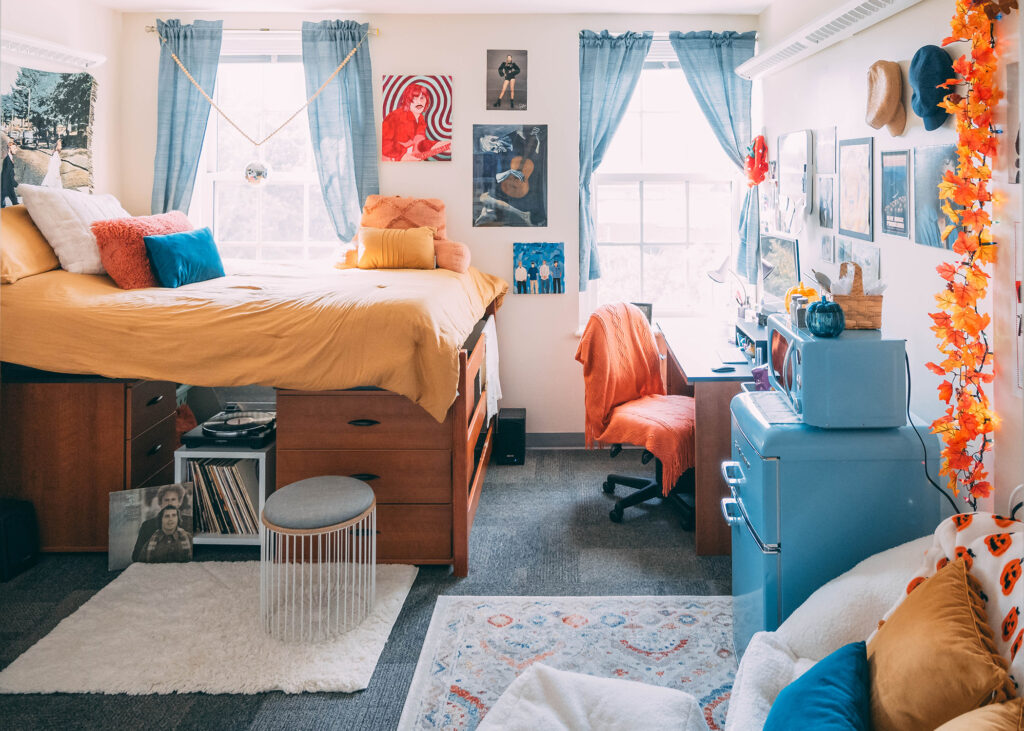 Dorm room decorated with in teal, mustard and orange tones. 
