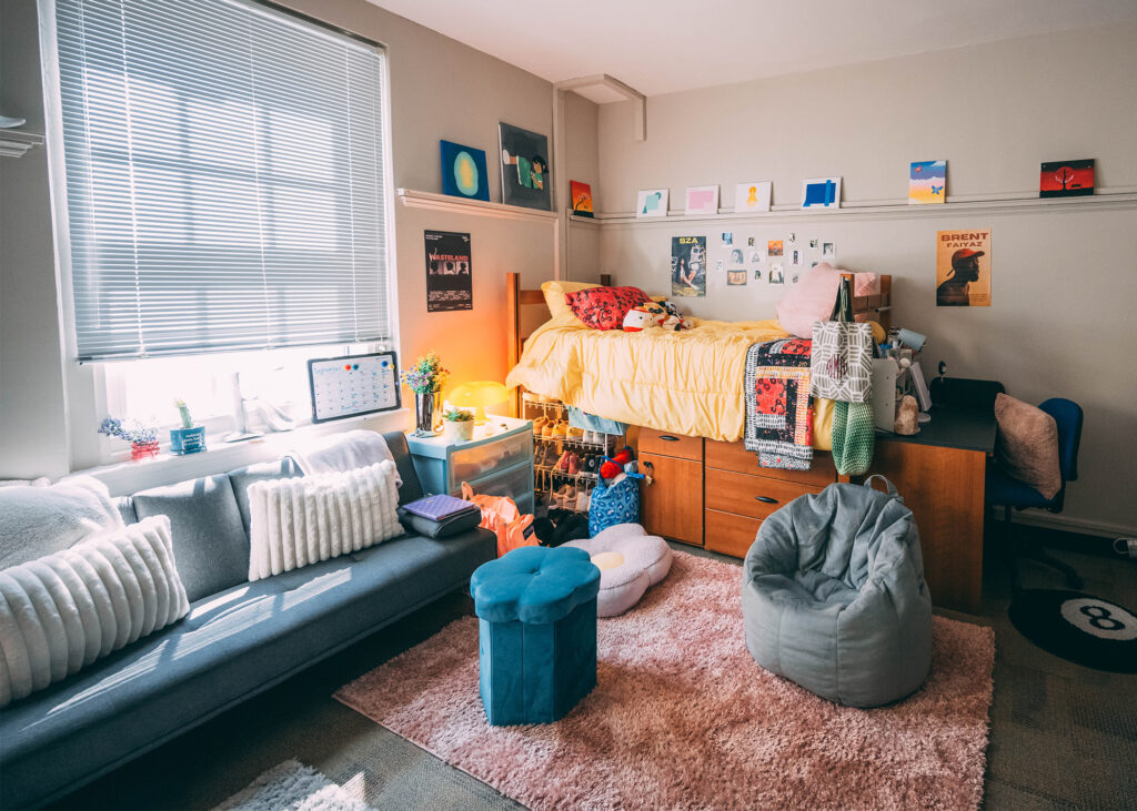 Dorm room decorated with bright colors, a sofa, and pillows. 