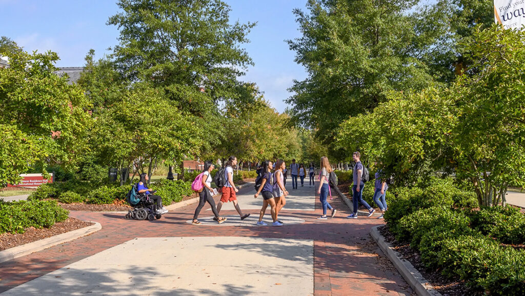 Students walk along College Avenue at UNCG.