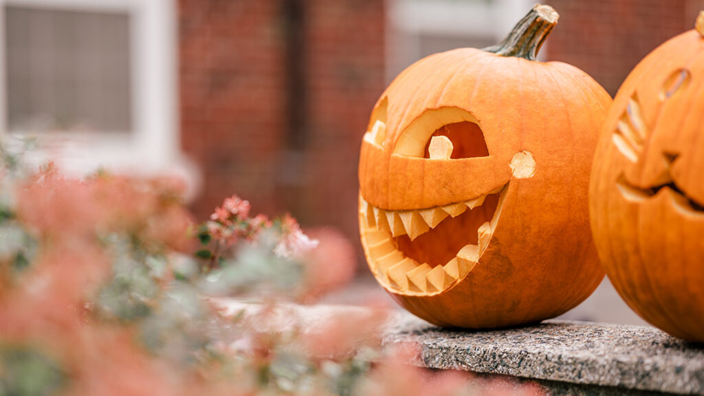 A jack-o-lantern sits atop a stoop at UNCG.