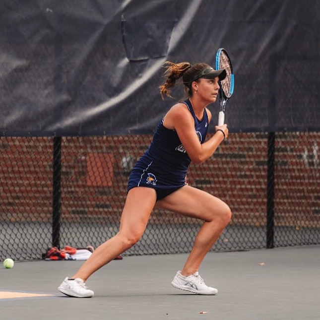UNCG tennis player on the court preparing to take a shot.