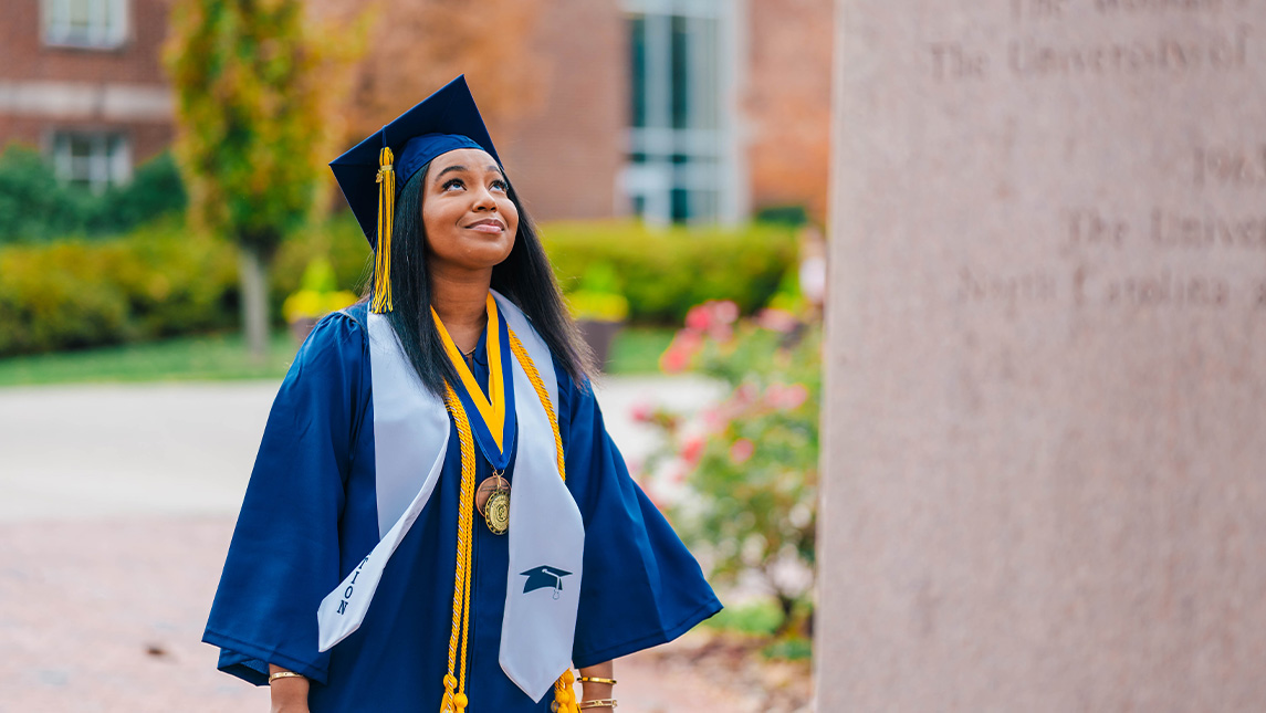 Graduate Kemiah Williams looking up at the Minerva statue.