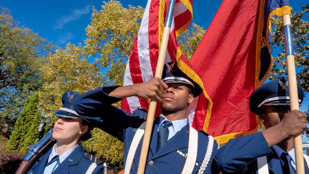 Students affiliated with the UNCG military hold flags