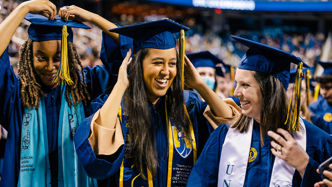 UNCG students smiling at commencement