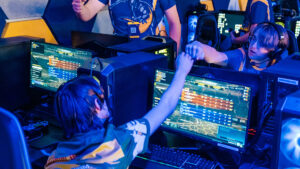 Two video gamers fist-bump each other in the UNCG esports arena.