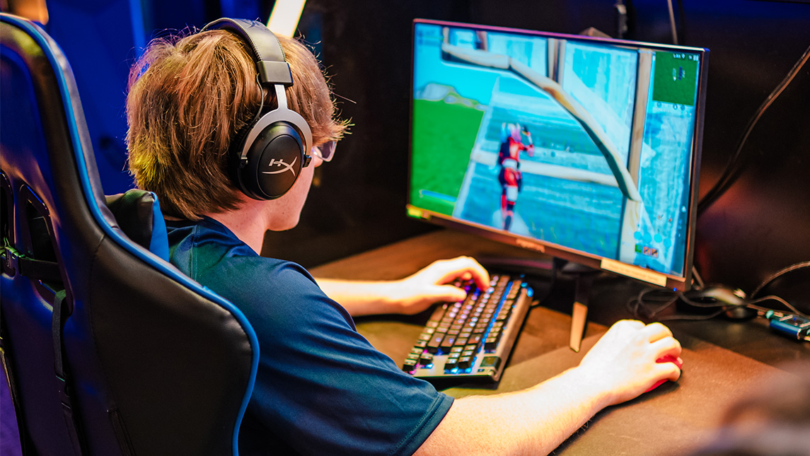 A student plays a video game on a PC in the UNCG esports arena.