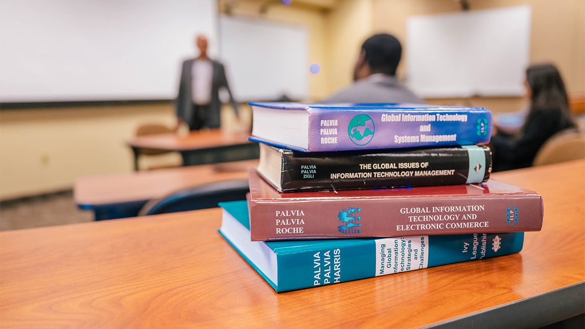 A stack of books in a UNCG classroom.