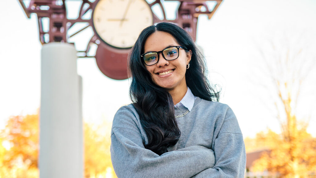 UNCG student Atheena Panama Tofaeono stands in front of the UNCG clock tower