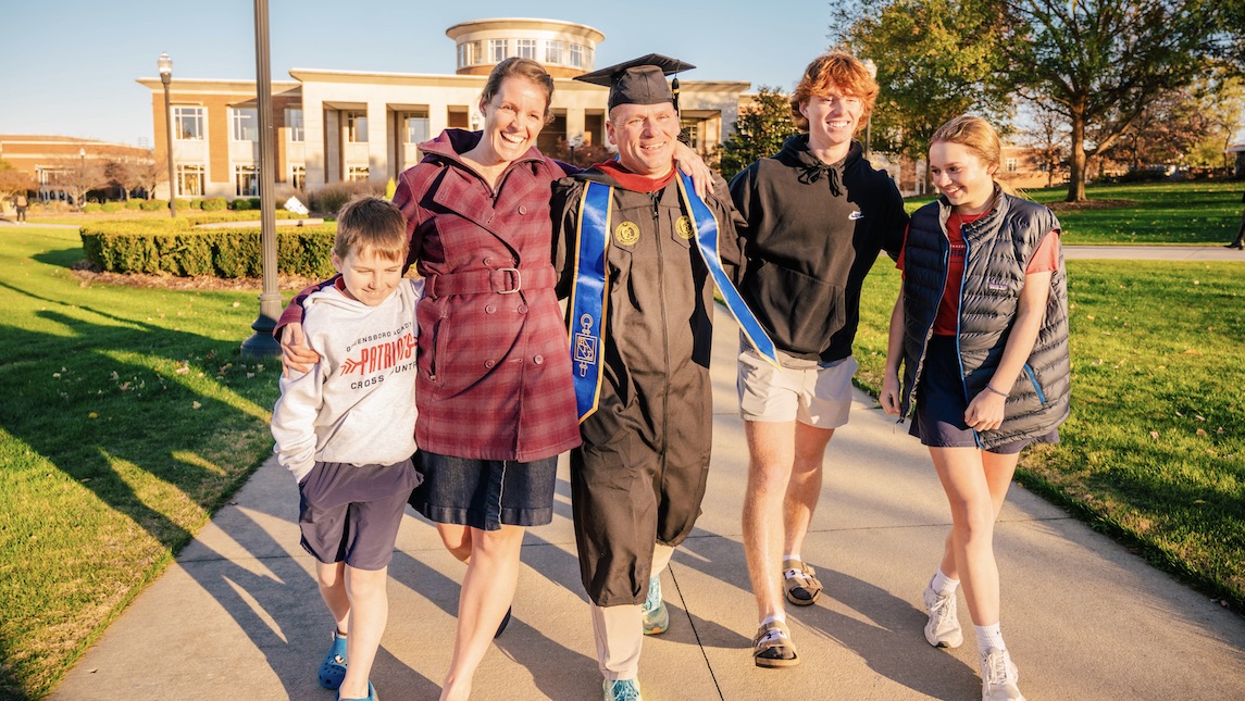 Nick Lofin has a fun photo op with his family in front of UNCG.