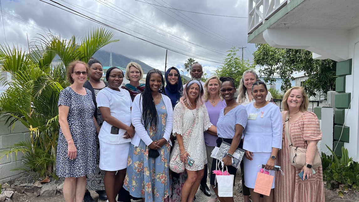 Synder poses with Nevis Faculty and students and community leaders.