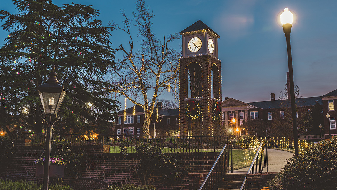Clocktower on UNCG campus decorated in lights and wreaths for the holidays.