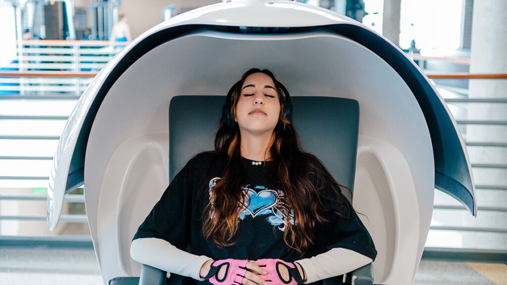 A UNCG student rests inside a Kaplan Center nap pod.