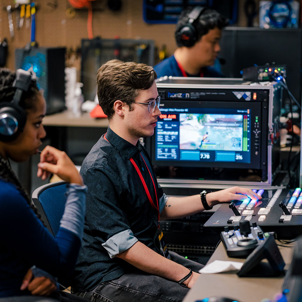 Student works a media broadcast board in the “war room” of the UNCG esports arena.