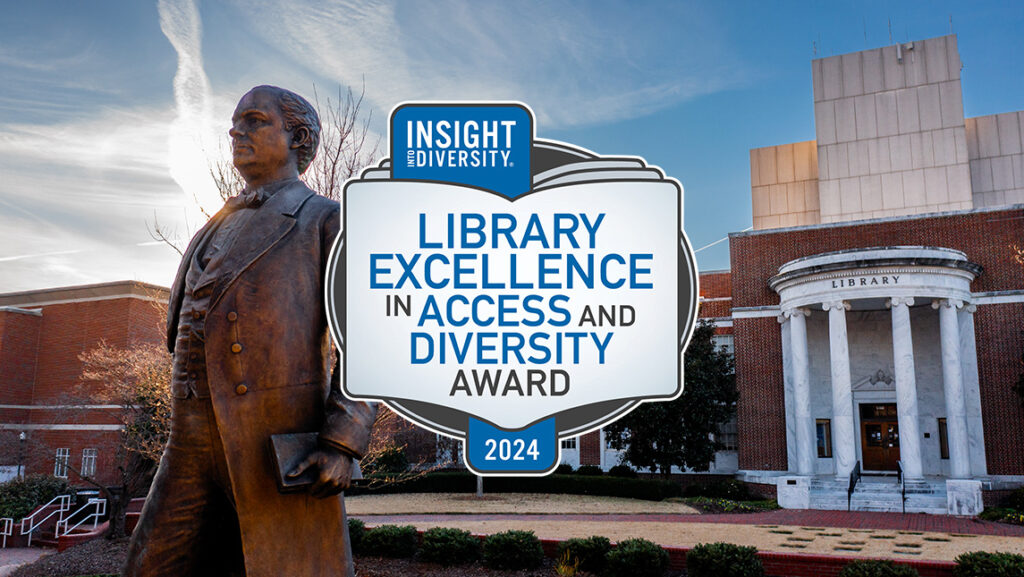 Photo of the McIver statue in front of Jackson Library. The Library Excellence in Access and Diversity Award logo is in front