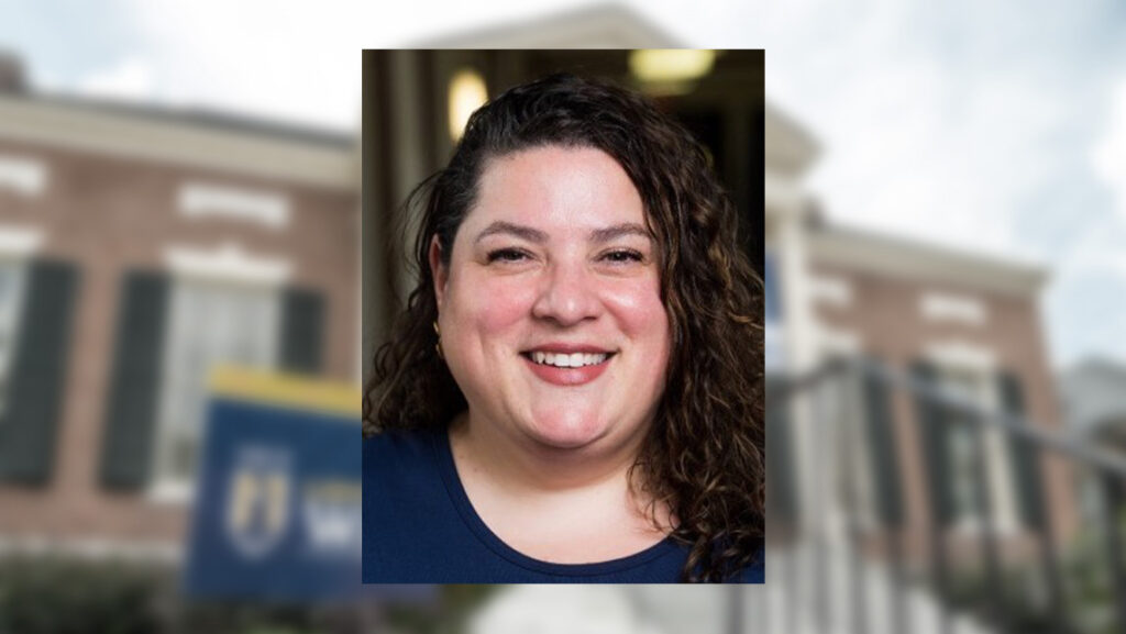 Headshot of Alejandra Merhab against a backdrop of the UNCG Alumni House.