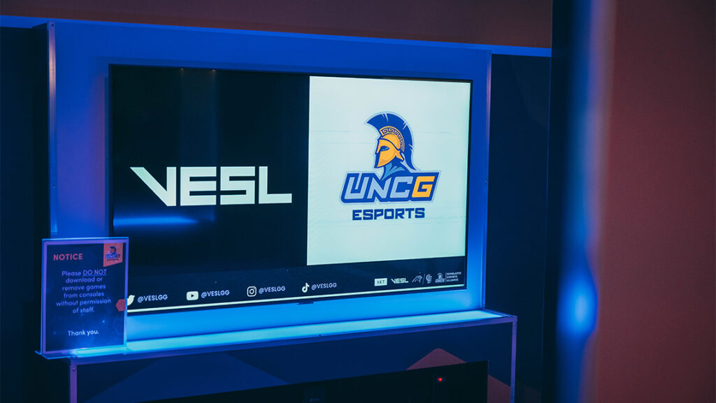 A display monitor promoting a esports tournament at UNCG.