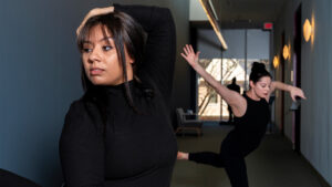 Dance students Tiffany Moss Hale and Liz Anderson pose in the Weatherspoon Art Museum hallway.