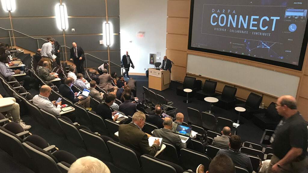 Participants walk into the UNCG JSNN auditorium for the conference DARPA Connect.