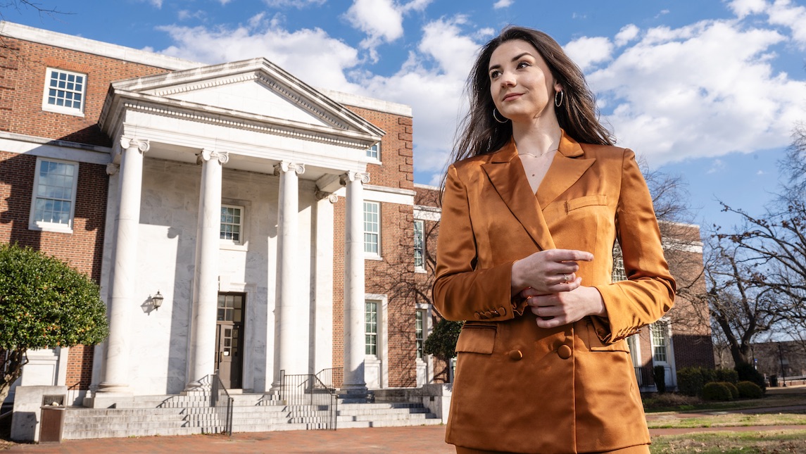 Cassidy Burel poses in front of UNCG's main campus building.