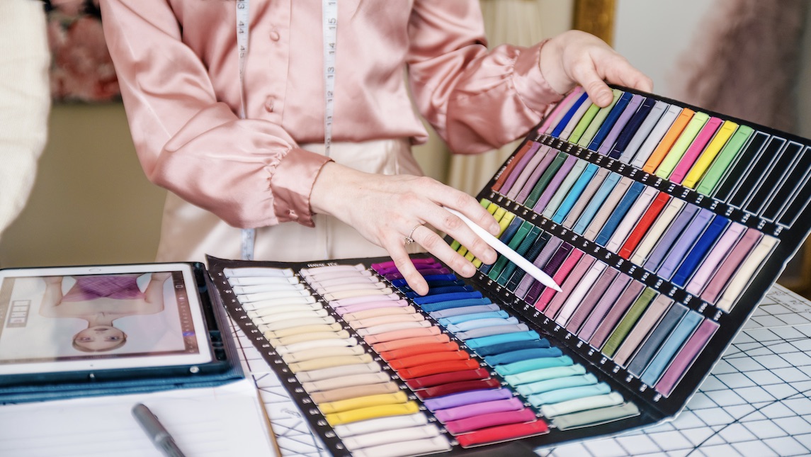 Cassidy Burel chooses a fabric color from a swatch book.