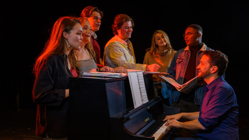 UNCG faculty Dom Amendum plays the piano while students sing