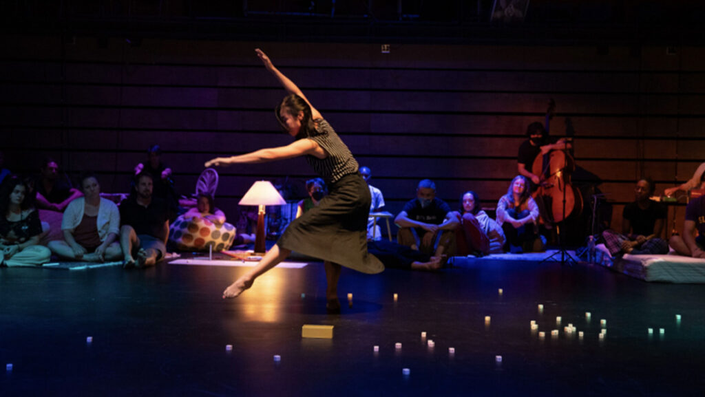 A person dances with their arms outstretched